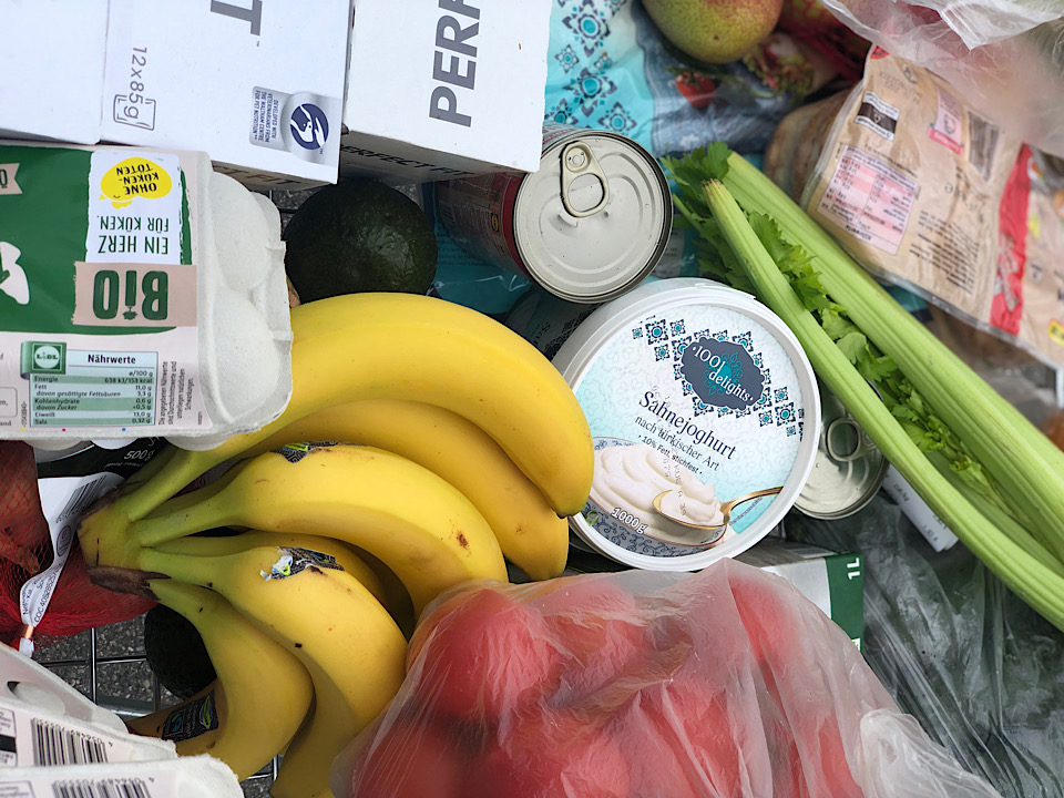 Einkaufkorb mit Bananen, Tomaten und Joghurt