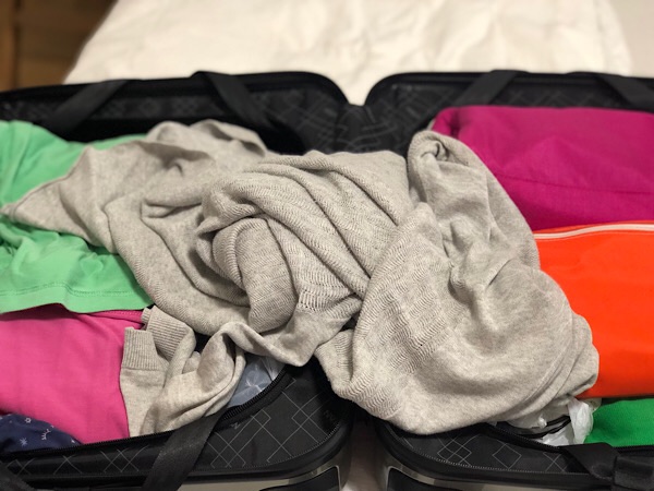 Ein geöffneter Koffer mit vielen bunten Kleidungsstücken